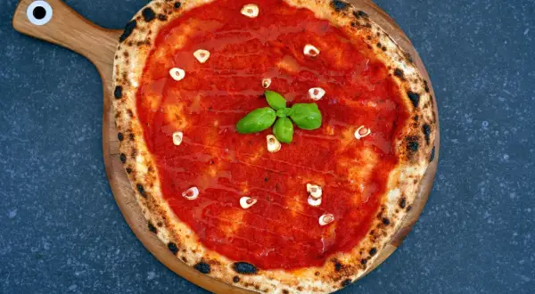 Pizza mit Tomatensauce, Knoblauch und Basilikum. Ein authentisches Rezept für Pizza Tomatensauce Original.
