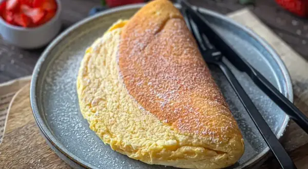 Puszysty omlet, idealny na śniadanie. Zobacz, jak zrobić omlet, który zachwyci smakiem i wyglądem. Posypany cukrem pudrem, czeka na Ciebie.