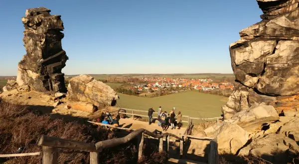 Felsformationen bei Blankenburg, ein echter Geheimtipp mit Blick auf ein malerisches Dorf. Wanderer genießen die Aussicht.
