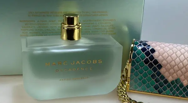 Flakon perfum Marc Jacobs Decadence Eau So Decadent obok ozdobnej torebki.