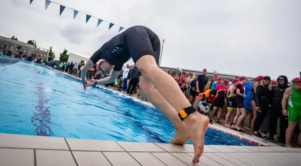 A swimmer poised to dive, embodying the motivation for swimmers to push their limits and embrace the challenge.