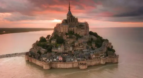 Bajkowy zamek na wodzie we Francji, Mont Saint-Michel, w blasku zachodzącego słońca.