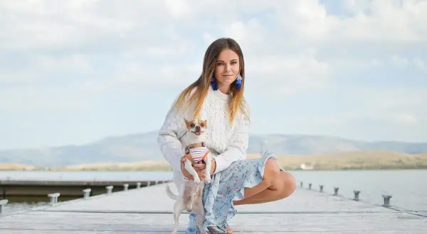 Dziewczyna z psem na molo. Jej styl, jak znaleźć swój styl test, jest swobodny i kobiecy.