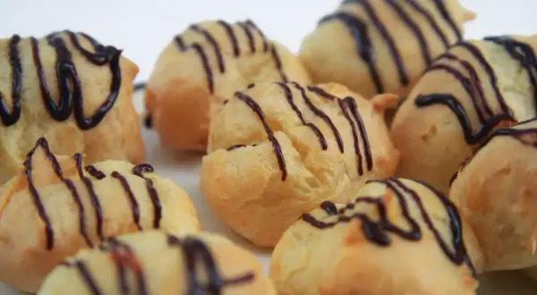 Montón de profiteroles con glaseado de chocolate. ¿De donde son los profiteroles? ¡De Francia, por supuesto!