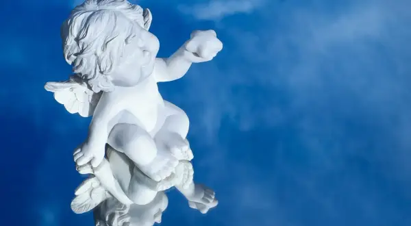 Biały cherubin odbija się w lustrze na tle błękitnego nieba. Jakby szukał światła, niczym w psalm 27 tekst.