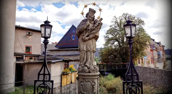 Kamienna figura świętego z gwiazdami nad głową, stojąca w malowniczym mieście w kotlinie jeleniogórskiej koło Karpacza.