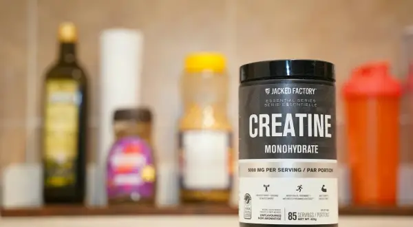 Kreatyna w dni nietreningowe to klucz do regeneracji i budowy mięśni. Słoik Jacked Factory Creatine Monohydrate na półce.