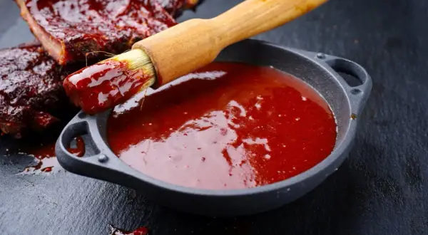 Pyszne żeberka w sosie BBQ, pędzelek zanurzony w sosie, idealny sos bbq przepis.