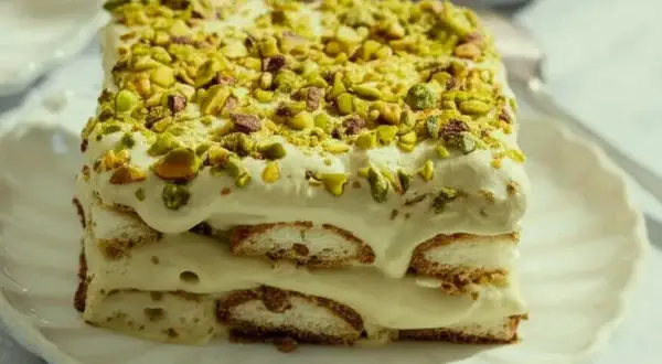 Un délicieux tiramisu pistache, superposé de biscuits et de crème onctueuse, le tout saupoudré de pistaches concassées.