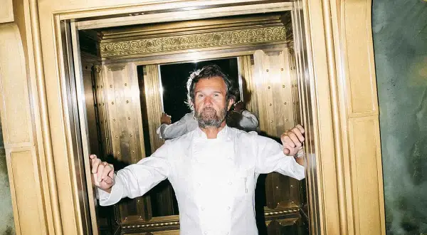 Lo chef Cracco, con la sua giacca bianca, in un ascensore dorato. Quante stelle Michelin ha Cracco?