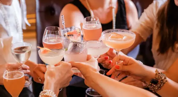 Kobiety wznoszą toast kolorowymi drinkami. Zastanawiasz się, ile kalorii ma drink?