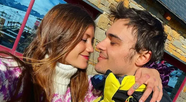 Eduardo Pérez-Cabrero y su pareja, una joven con cabello castaño, se miran tiernamente con nieve de fondo.
