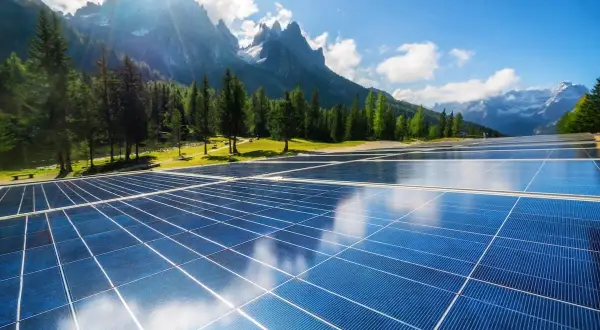 Panele słoneczne na tle górskiego krajobrazu. Czysta energia dla domu, jak w taryfie G13 Tauron.
