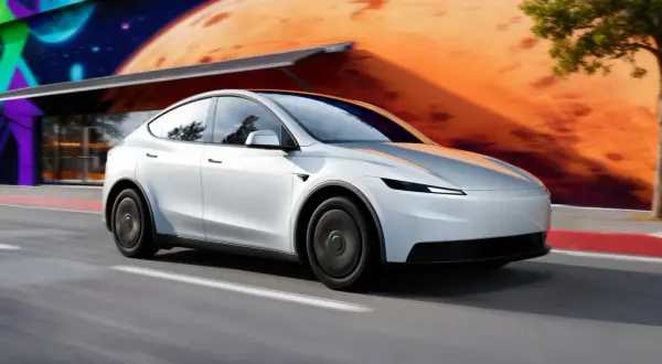 Biała Tesla Model Y pędzi po drodze. Zastanawiasz się, ile kosztuje najnowsza Tesla?