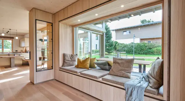 Gemütliche **Ideen für Sitzfenster**: Ein einladender Bereich mit Kissen und Decke lädt zum Verweilen ein, während der Blick ins Grüne schweift.