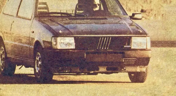 Ciemny Fiat Uno Turbo z kierowcą za kierownicą, gotowy do jazdy.