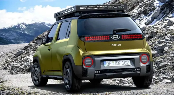 Złoty Hyundai Inster na górskiej drodze. Sprawdź hyundai inster cena i wybierz się na przygodę!