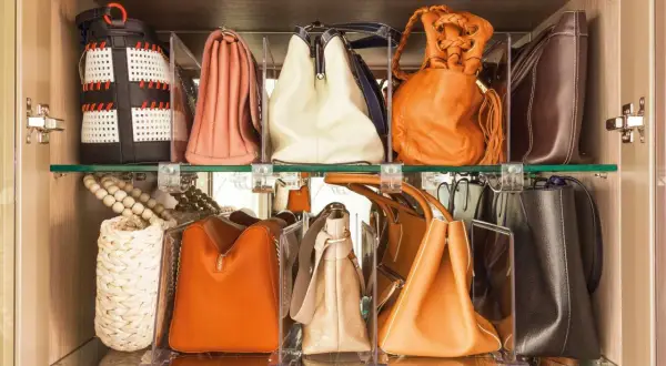 Estantería con varios bolsos de diferentes colores y estilos, perfectamente organizados para facilitar su acceso.