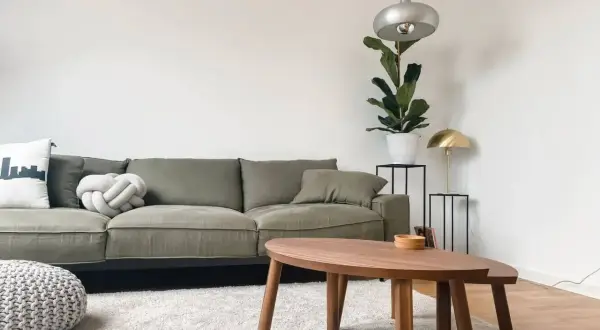 Grüne Couch, die durchgesessen ist, aber mit neuen Kissen und einem Pouf wirkt sie frisch. Ideen für couch durchgesessen aufpolstern selber machen.