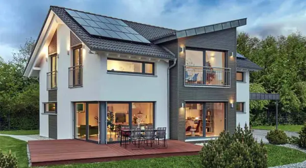 Modernes Haus mit Solaranlage auf dem Dach und großzügigen Fenstern im **Erdgeschoss**, die Einblicke in gemütliche Wohnbereiche gewähren.