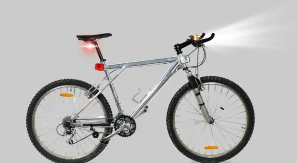 Silver mountainbike med fram- och bakljus samt ringklocka. All cykel utrustning är på plats för en säker tur.