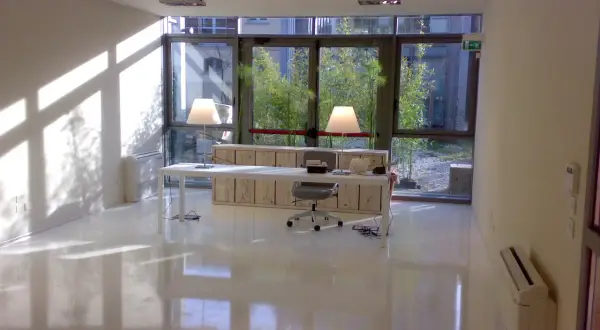 Ufficio moderno con pavimento in resina lucida, ideale per chi cerca un design minimalista e vuole conoscere i prezzi pavimenti in resina.