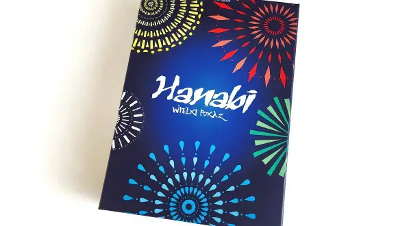 Pudełko gry karcianej Hanabi z kolorowymi fajerwerkami na ciemnoniebieskim tle.