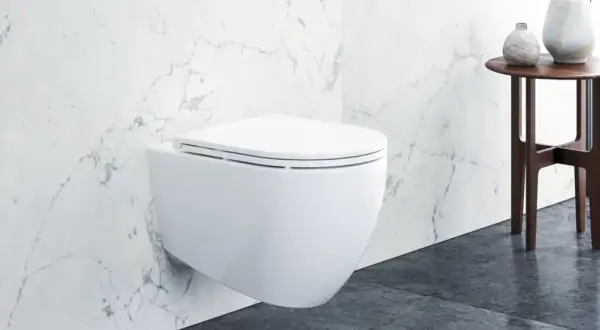 Modernes wandhängendes WC mit Klodeckel montieren. Marmorfliesen und ein Beistelltisch mit Vasen im Hintergrund.