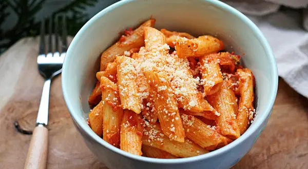 Penne z sosem pomidorowym, posypane parmezanem. Idealne danie z pomidorkami datterini.