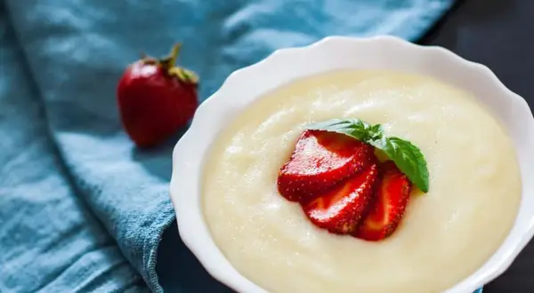 Gładka kaszka, czyli semolina, podana z truskawkami i miętą. Idealna na śniadanie.