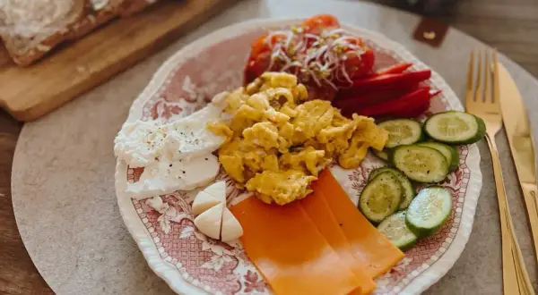 Szybkie zdrowe śniadanie: jajecznica, ser, pomidory, ogórek i pieczywo. Idealny start dnia!