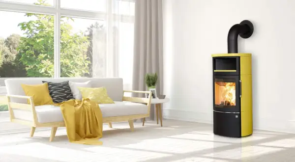 Moderner Kaminofen in Gelb und Schwarz mit brennendem Holz. Der Ofenrohr Abstand zum Holz ist sicher eingehalten.