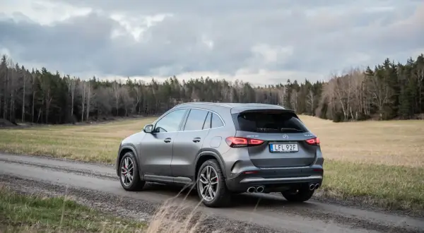 Grå Mercedes GLA 45 AMG på grusväg i skogen, med molnigt väder. Kanske ett problem med terrängkörning?