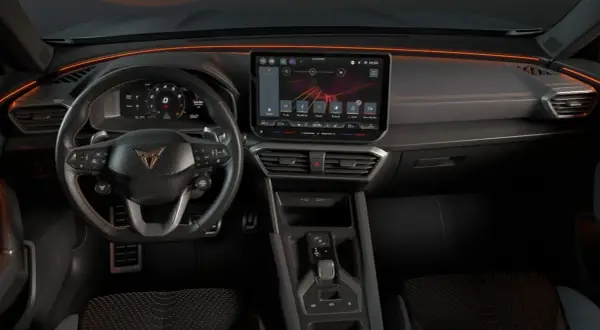 Interior del Cupra Formentor con pantalla táctil, volante deportivo y luces ambientales naranjas.