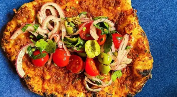Lahmacun med färsk topping av tomat, lök och oliver. Ett enkelt lahmacun recept att prova.