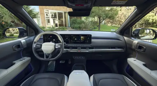 Interior del Kia EV3 con pantalla táctil panorámica, volante moderno y asientos de dos tonos.