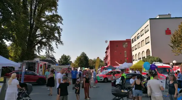 Menschen genießen das Stadtfest Bergisch Gladbach bei Sonnenschein. Einsatzfahrzeuge und Stände säumen die belebte Straße.