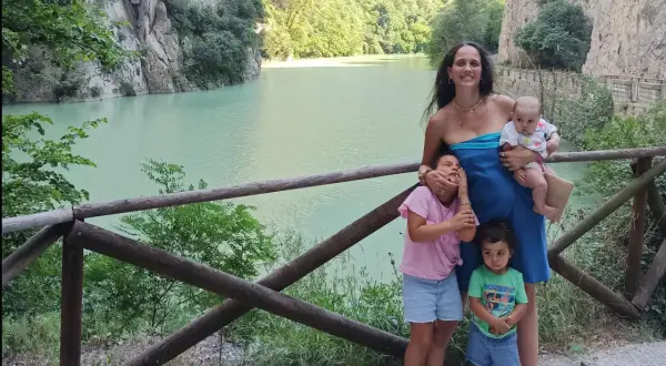 Famiglia felice nella Gola del Furlo, con un lago turchese e rocce imponenti.