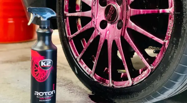 Płyn K2 Roton w sprayu, idealny do czyszczenia felg aluminiowych. Widoczny na różowych felgach, skutecznie usuwa zabrudzenia.