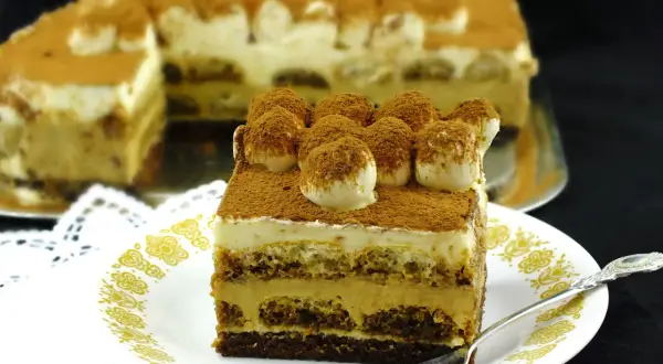 Pyszny sernik tiramisu, warstwowy deser z kremem i biszkoptami, posypany kakao.
