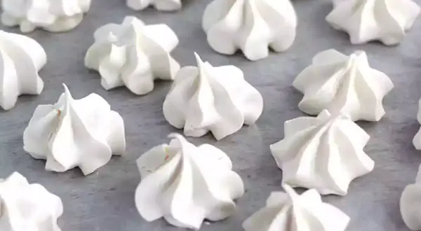 Une belle **recette meringue** : des petits nuages blancs et aériens disposés sur une plaque.