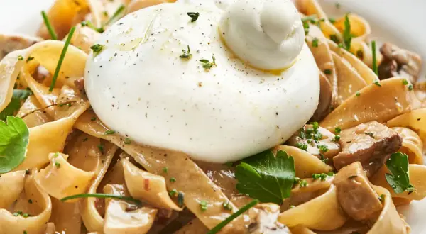 Pasta mit Pilzen und cremiger Burrata, ein köstliches italienisches Gericht.