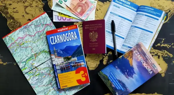 Paszport, pieniądze i przewodniki po Czarnogórze leżą na mapie świata. Czy do Czarnogóry potrzebny jest paszport? Tak, ten polski paszport jest gotowy do podróży!