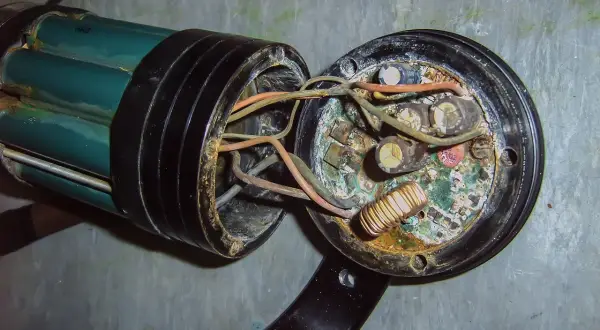 Uszkodzona instalacja elektryczna w domu, objawy: spalone przewody, skorodowane kondensatory i cewka.