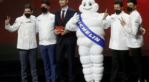 Chefs celebran con el muñeco Michelin, un símbolo de excelencia culinaria y 5 estrellas Michelin.