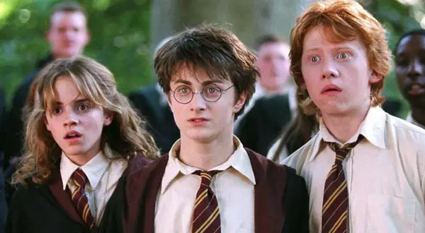 Harry, Ron i Hermiona w szkolnych szatach, gotowi na kolejne przygody w świecie magii. To początek ich historii, kluczowy moment w harry potter chronologia.