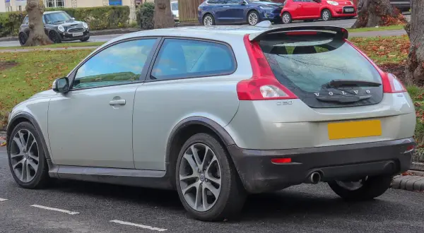 Srebrne Volvo C30 z charakterystycznym tyłem i spoilerem, zaparkowane na ulicy.