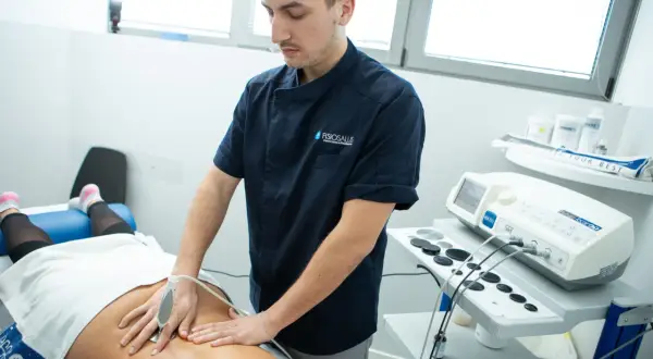 Fisioterapista esegue trattamento su schiena bloccata con apparecchiatura Tecar. Soluzione per il mal di schiena.