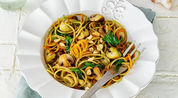 Leckere Spaghetti-Rezepte mit Pilzen, Karottenstreifen und Spinat, garniert mit Nüssen.