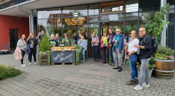 Eine Gruppe genießt Wein vor dem Meersburger Winzerverein. Herzlich willkommen!